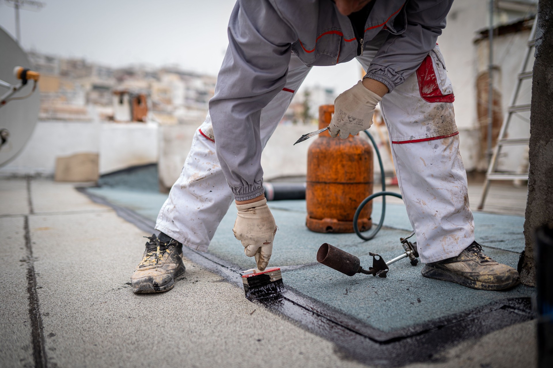 Roll roofing Installation with propane blowtorch during construction works